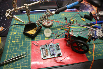 Photo of microcircuits. Process of creating mini robot. On background of blurring parts, soldering...