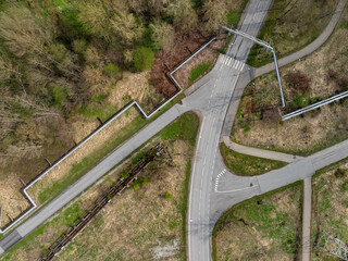 Aerial top-down view of road intersection in Kohtla-Jarve (Estonian - Kohtla-J&auml;rve), Estonia. Roads, crosswalks, pipelines, and greenery create geometric patterns blending infrastructure and nature