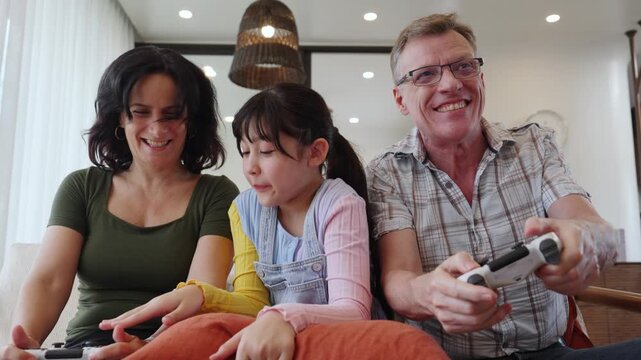 Granddaughter guide grandmother how to play console game with grandfather. Senior use technology activity communicate new generation kid cross generation gap strengthen family bond. Divergence.