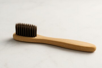 Bamboo toothbrush with dark bristles on white marble background, soft light and clear space for text, natural wellness concept for eco friendly branding and health visuals
