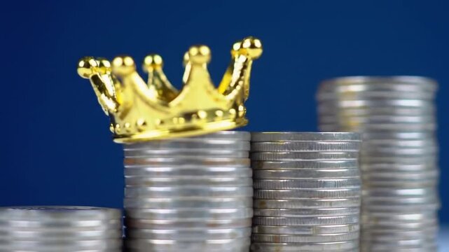 Stack of Coins Topped with Golden Crown on Deep Blue Symbolizing Investment and Wealth Growth
