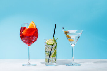 A variety of cocktails arranged on a table against a light blue background