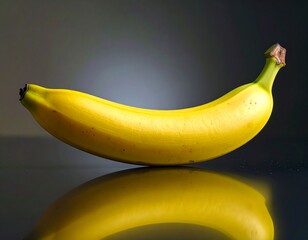 A whole banana is placed on a shiny reflective surface