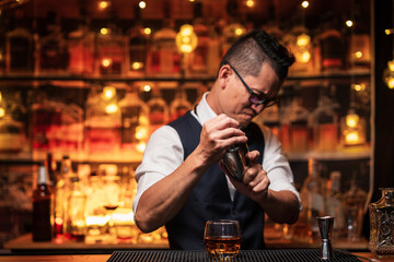 Bartender is pouring whiskey into a glass in a restaurant
