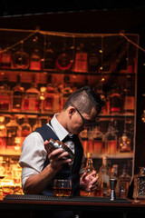 Bartender is pouring whiskey into a glass in a restaurant