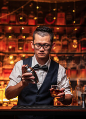Bartender is pouring whiskey into a glass in a restaurant