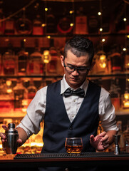 Bartender is pouring whiskey into a glass in a restaurant