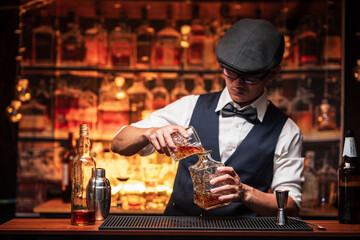 Bartender is pouring whiskey into a glass in a restaurant