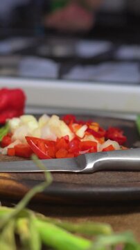 Chopping ajie cebolla and cebollin in a lively kitchen setting. Bright colors and fresh ingredients create an inviting atmosphere, perfect for showcasing Latin American culinary traditions.
