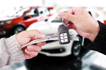 Car buying deal with cash and key exchange, symbolizing vehicle purchase or auto ownership transfer.