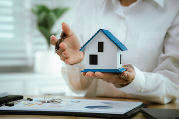 Real estate agents present home designs and discuss documents that reflect real estate investing,...