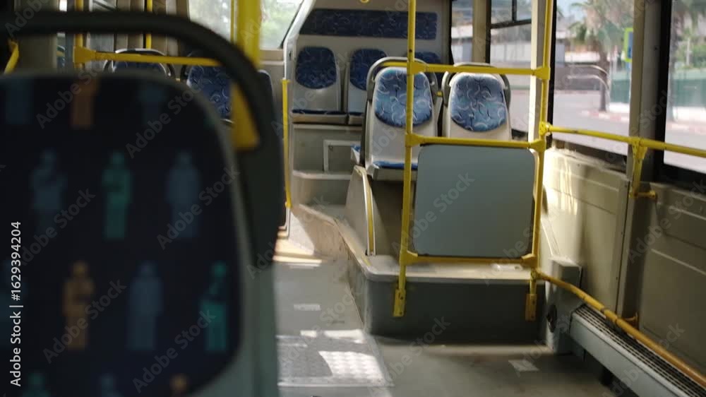 Poster bright daylight fills the empty bus interior, highlighting the step area and casting shadows on the 