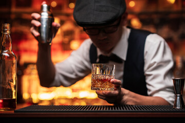 Bartender is pouring whiskey into a glass in a restaurant