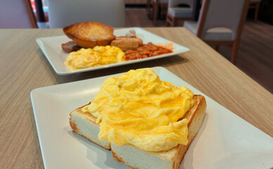 Close-up of creamy scrambled eggs on thick toast served in a Hong Kong-style café. Dining in a restaurant serving breakfast menu.