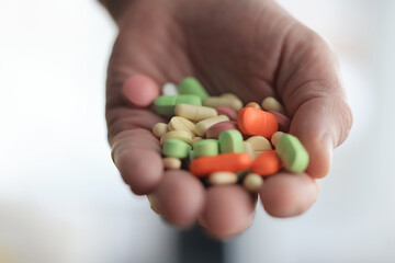 a lot of pills in the palm of a person's hand, medical background