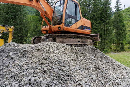 Large excavator on a pile of gravel