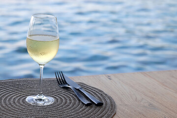 glass of cold white wine on the summer seashore by the water, relaxing by the water, a gentle background of soft color