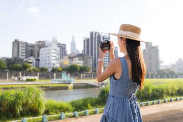 Fototapeta premium Travel woman taking photo with camera Taipei city