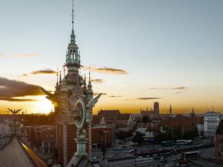 Gdańsk cityscape at golden hour with winged statue and old town skyline