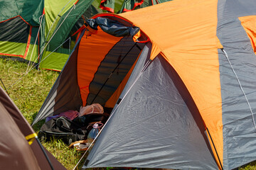 A tent with a red and gray canopy is set up in a field