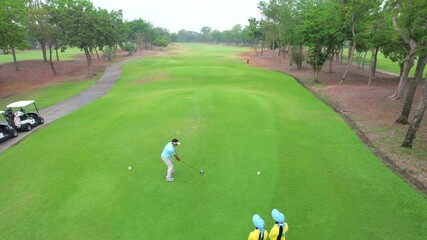 Drone view of professional male golfer playing on scenic golf course. - Powered by Adobe
