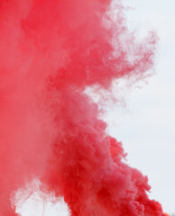 A red cloud of smoke is billowing into the sky
