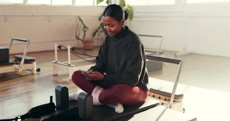 Phone, pilates and smile of woman on studio floor for break from exercise or fitness routine. App, social media and text message with happy person in health class for communication or recovery
