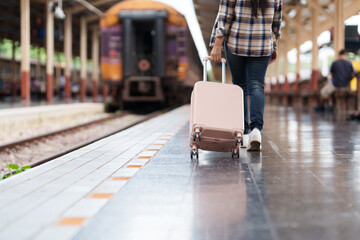 Tourist walking with luggage at railway station platform