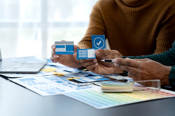 Creative team collaborates on modern UI UX design project with wireframes and color swatches.