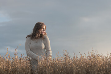 Summer Look female model posing in a field against the sky, the concept of natural freedom and...