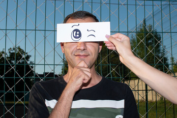 Portrait of a man with a funny drawn paper eyes