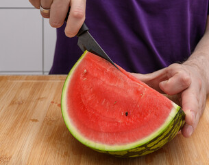 Dad cutting watermelon into smaller portions, light summer snack for kids, ripe juicy watermelon