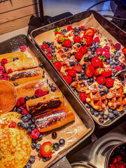 Delicious breakfast buffet with golden pancakes, crispy waffles, and sweet berries. Perfect food concept image for hotel breakfast, brunch menu, or healthy eating visuals. High quality photo