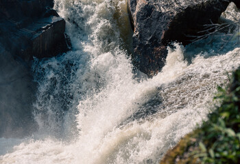 streams of clear waterfall water and stone banks of a mountain river