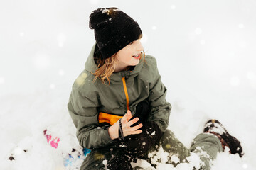 Pre-teen smiling in snow during playful winter day