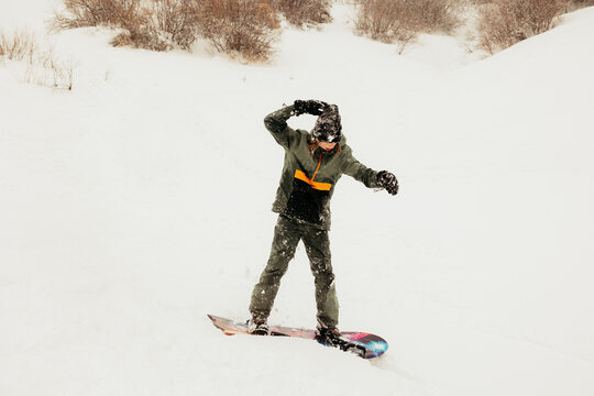 Snowboarder balancing on snowy slope during winter sports activity