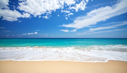 Serene beach scene with turquoise water, white waves lapping sandy shore under a bright blue sky