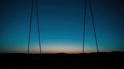 Empty swings silhouette at sunset