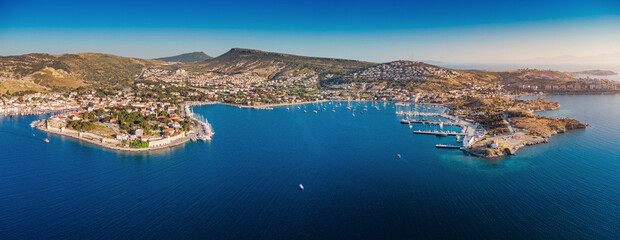 Aerial panorama of Foca, Turkey, historic coastal town with marina, fortress walls and red rooftops on the Aegean Sea