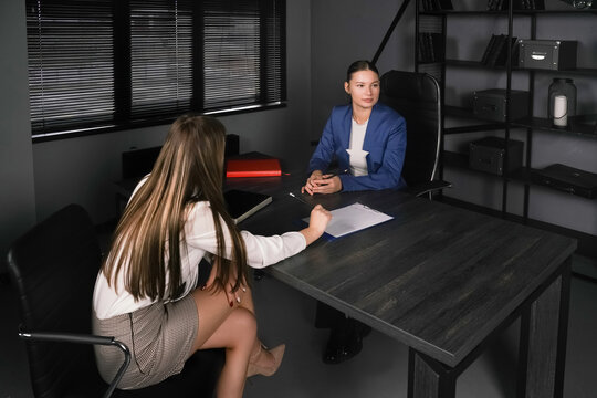 Business interview taking place in a modern office setting with two women discussing opportunities