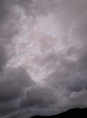 dark rain clouds float across the blue sky, evening, sunset, lightning illuminates the storm...