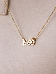 Close-up of a metallic gold pendant in the shape of 