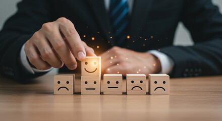 Businessperson Holding Glowing Happy Face Block Among Emotion Icons on Table