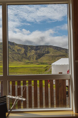 Fototapeta premium Lush Green Valley and Rugged Hills Framed by a Window in Iceland