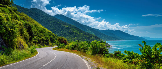Winding coastal road reveals breathtaking views of mountains and ocean under a vibrant blue sky