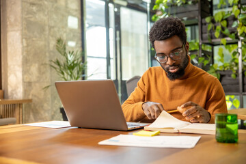 Remote male consultant managing clients online while seated at desk