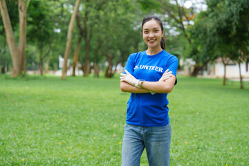 Volunteer smiling with crossed arms in park