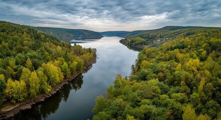 Obraz premium The river winds its way through a golden forest from an aerial perspective