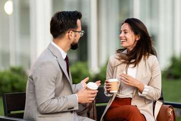 Business people talking and drinking coffee outdoors during break time