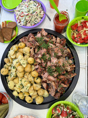 Set dining table with potatoes, kebabs salads